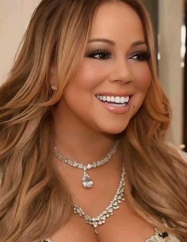 The famous Mariah Carey teeth today, showing a perfectly straight, bright white, and symmetrical Hollywood smile, likely the result of porcelain veneers.