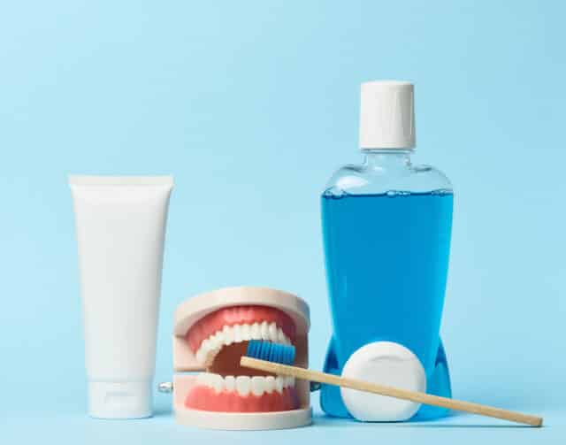 A person using dental floss to clean between their teeth. Daily flossing is a key component of effective oral hygiene tips for preventing plaque buildup.